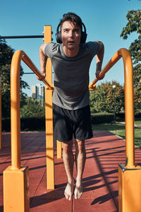 Young man doing dips on parallel bars during his workout in a modern calisthenics street workout