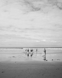 People on beach against sky