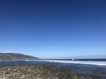 Scenic view of sea against clear blue sky