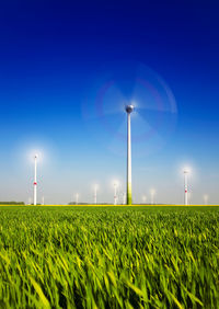 Windmill on field against clear sky at night