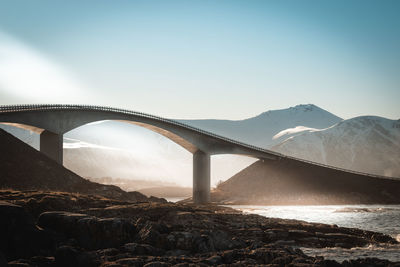 Arch bridge over mountains against clear sky