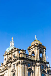 Low angle view of church against clear blue sky during sunny day