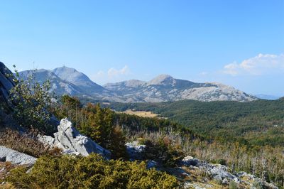 Scenic view of mountains against blue sky