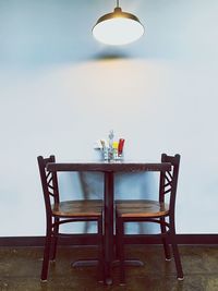 Table and chairs against sky
