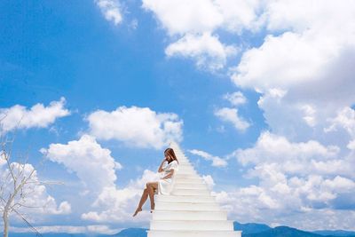 Low angle view of woman standing against sky