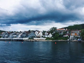 Houses by sea against sky