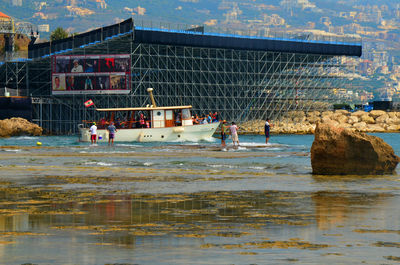 People at sea shore against sky