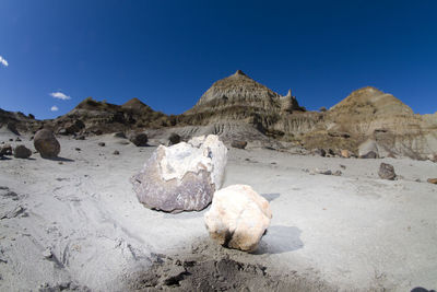 Rock formations on landscape against blue sky