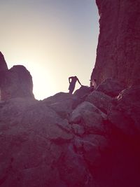 Man on cliff against sky