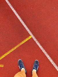 Low section of man standing on running track
