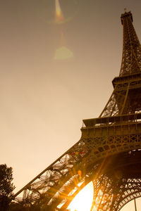 Low angle view of illuminated tower against sky during sunset