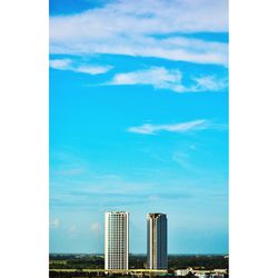 Buildings in city against cloudy sky