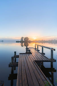 Pier over sea against sky during sunset
