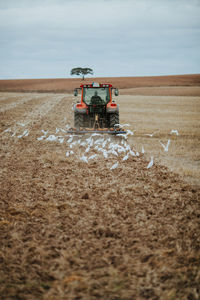 Tractor on agricultural field against sky