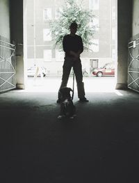 Full length rear view of man standing against window