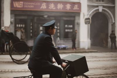 Man sitting on street in city