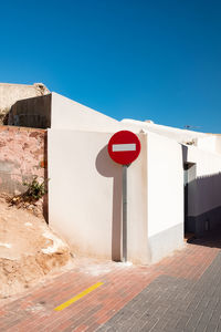 Road sign against clear blue sky