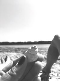 Low section of man on beach against clear sky