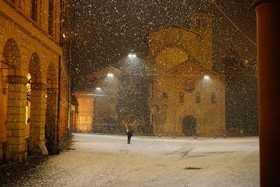 Rear view of man walking on street in city during winter