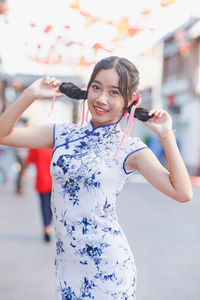 Portrait of smiling teenager girl holding braids