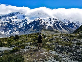 Rear view of man walking on mountain during winter