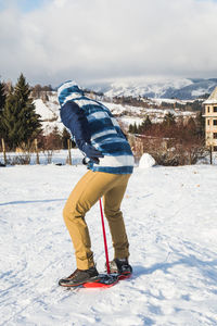 Man learning to snowboard during winter