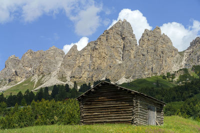 Panoramic shot of cottage on mountain against sky