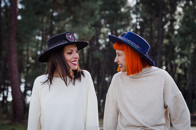 Smiling women wearing hat standing in forest