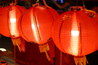 Low angle view of illuminated lanterns hanging at night