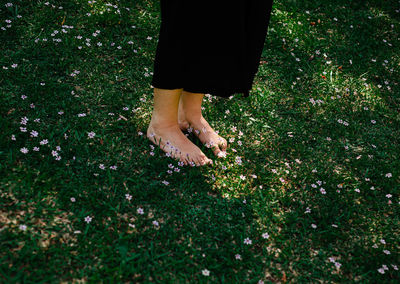 Low section of woman standing on grass