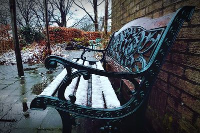 Empty bench in park during winter