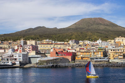 Scenic view of torre del greco and vesuvio by sea against sky