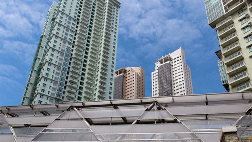 Low angle view of modern building against cloudy sky