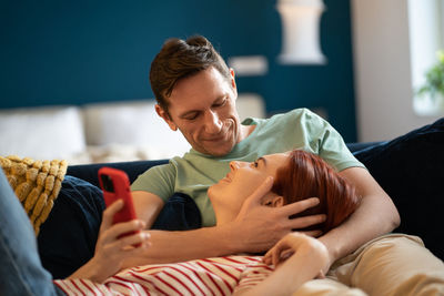 Woman lying on man lap. guy hugs girl while relaxing on couch. intimacy, closeness, love, care