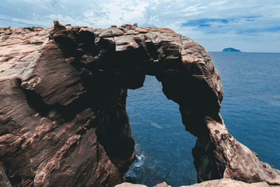 Rock formations by sea against sky