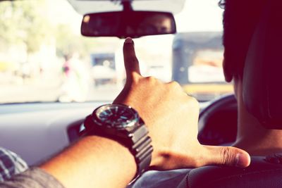 Cropped hand of man gesturing in car