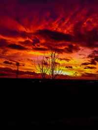 Silhouette landscape against orange sky