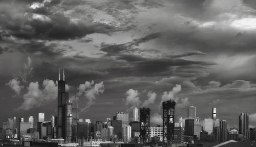 Buildings in city against cloudy sky