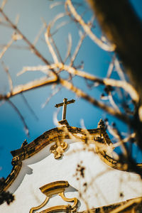 Low angle view of cross on building against sky