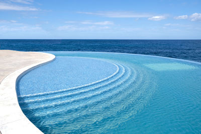 Sea water pool with stairs for relaxing, sea views. blue clear water surface in swimming pool. 