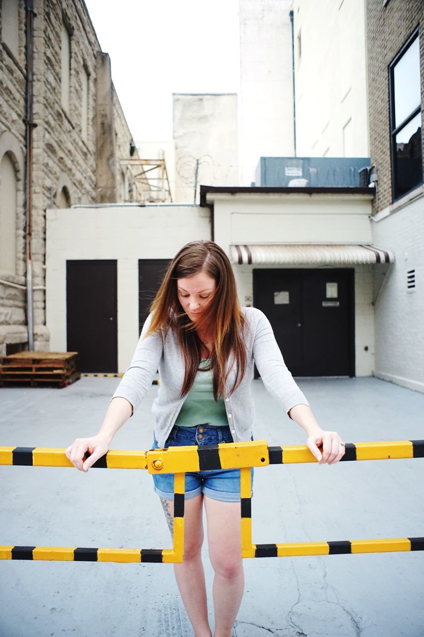 young adult, person, lifestyles, casual clothing, young women, looking at camera, portrait, front view, smiling, happiness, long hair, leisure activity, standing, built structure, architecture, three quarter length, waist up