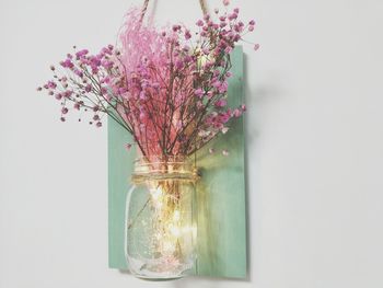 Close-up of flower vase against white wall