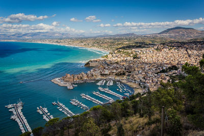 High angle view of town by sea against sky