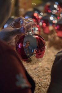 Close-up of hand holding glass reflection