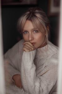 Portrait of beautiful young woman wearing sweater at home