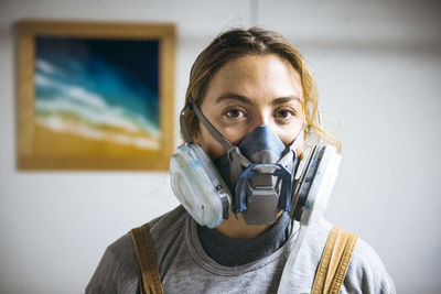 Portrait of female resin artist in homemade art studio with respirator