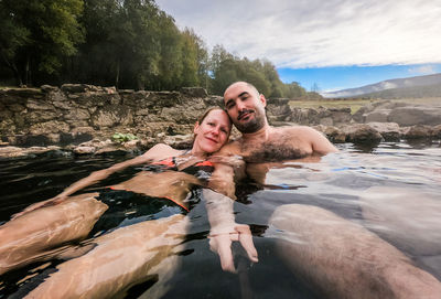 Portrait of couple sitting in hot spring