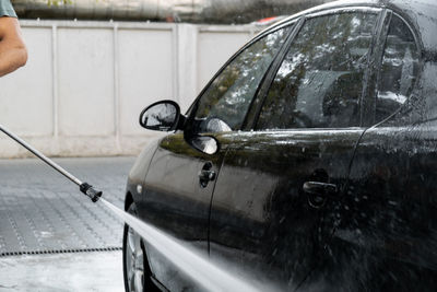 Close-up of man washing car
