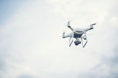 Low angle view of quadcopter flying against sky