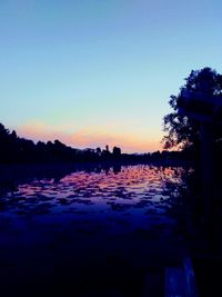 Scenic view of lake against clear sky during sunset